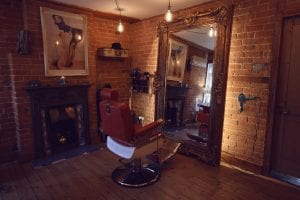 Red leather barbers chair and wall tall grand mirror