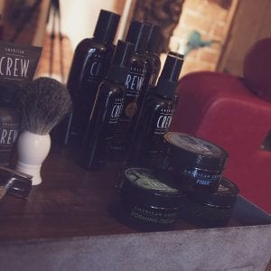 A close up photo of a selection of crew styling products and a small brush